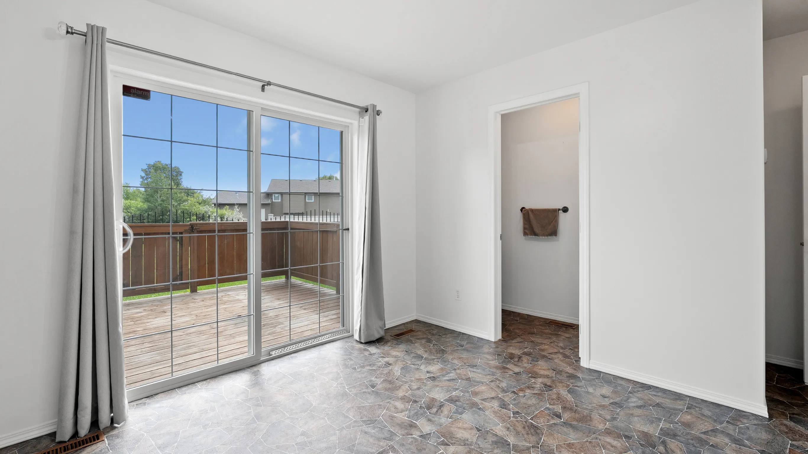 Open panoramic glass doors creating a seamless transition between the living room and the outdoor wooden deck in Los Angeles by Dream Patios LA.